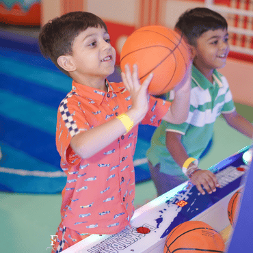 Child playing basketball during an indoor game at Wooray Delhi play area.
