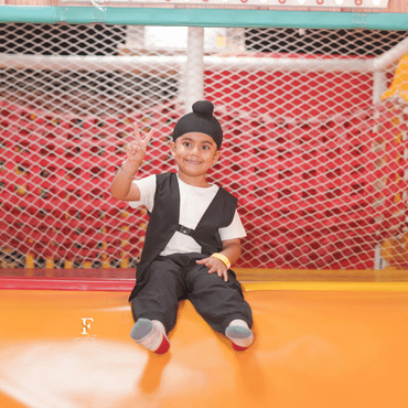 Child enjoying an exciting indoor slide at Wooray Delhi play area.