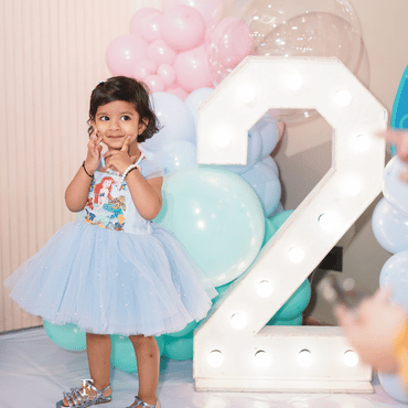 Child celebrating a birthday in a beautiful blue dress at Wooray Delhi.