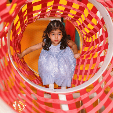 Child exploring a colourful indoor play tunnel at Wooray Delhi.